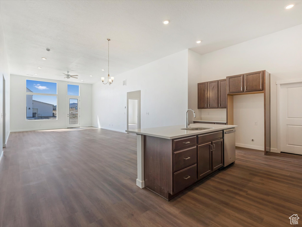 Kitchen featuring sink, decorative light fixtures, a kitchen island with sink, dark hardwood / wood-style floors, and dishwasher