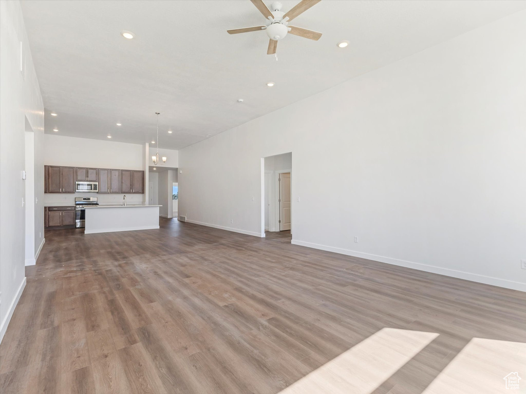 Unfurnished living room featuring ceiling fan and light wood-type flooring