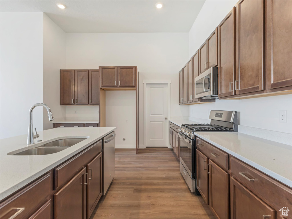 Kitchen with hardwood / wood-style flooring, sink, and stainless steel appliances