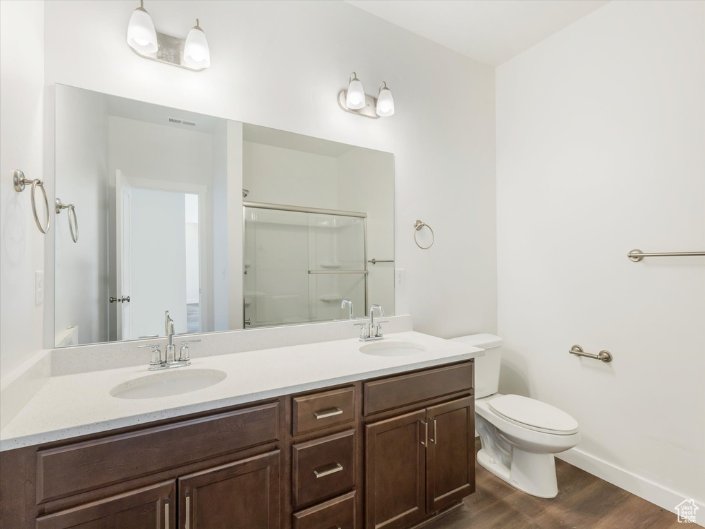 Bathroom with toilet, walk in shower, vanity, and wood-type flooring