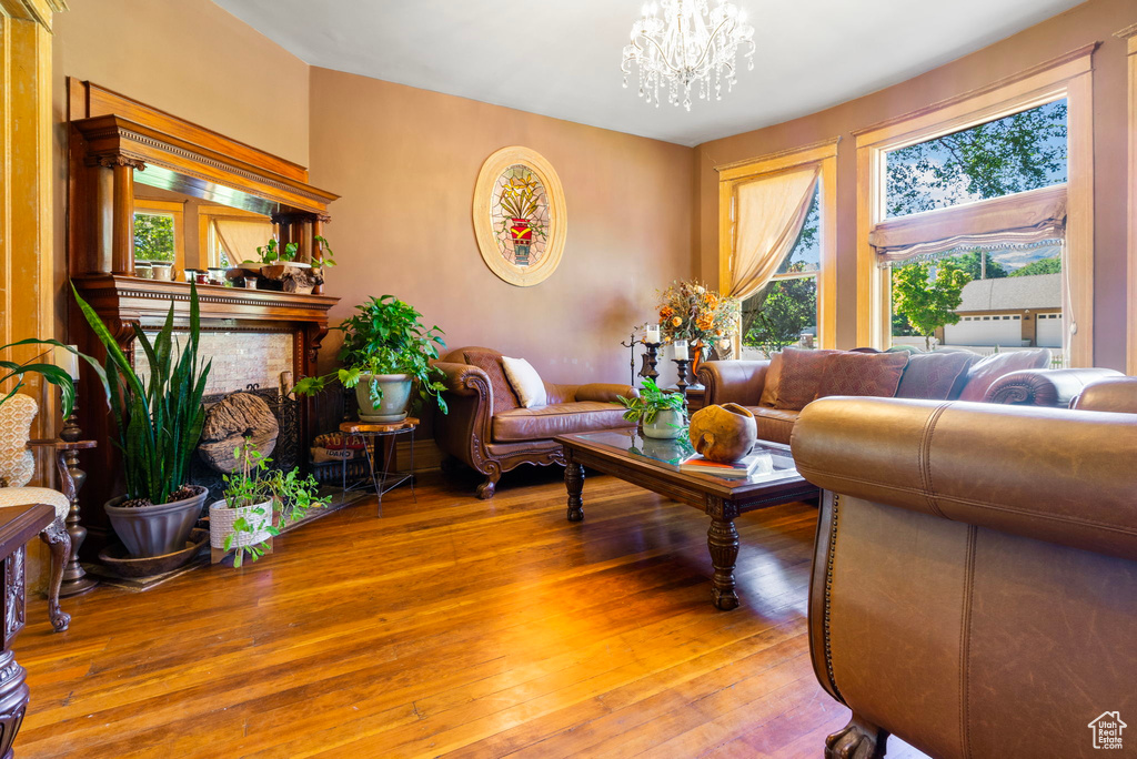 Living room featuring a wealth of natural light, light hardwood / wood-style flooring, and a chandelier