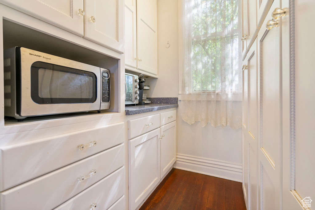 Kitchen featuring dark wood-type flooring and white cabinets