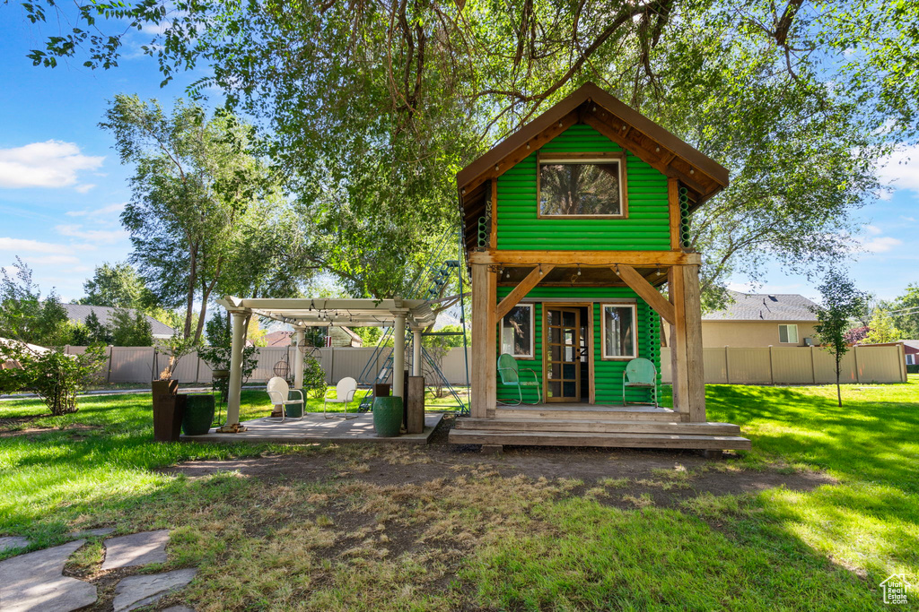 View of front of house featuring a pergola and a front lawn