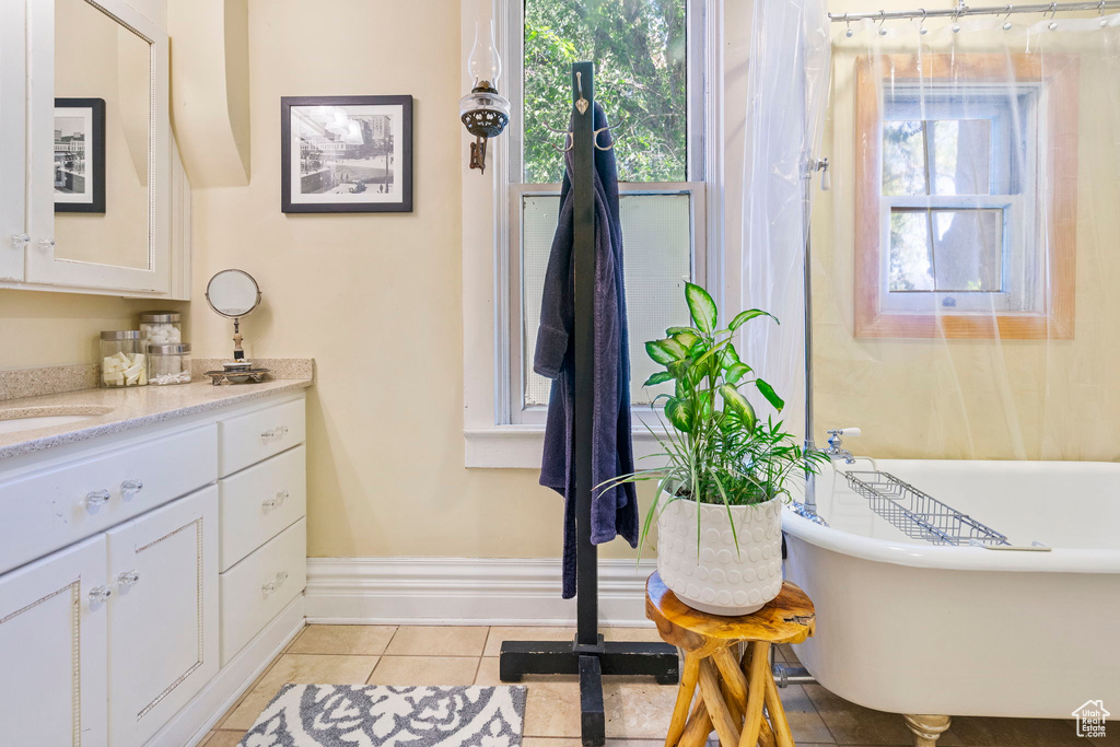 Bathroom featuring a bathtub, tile patterned floors, and vanity