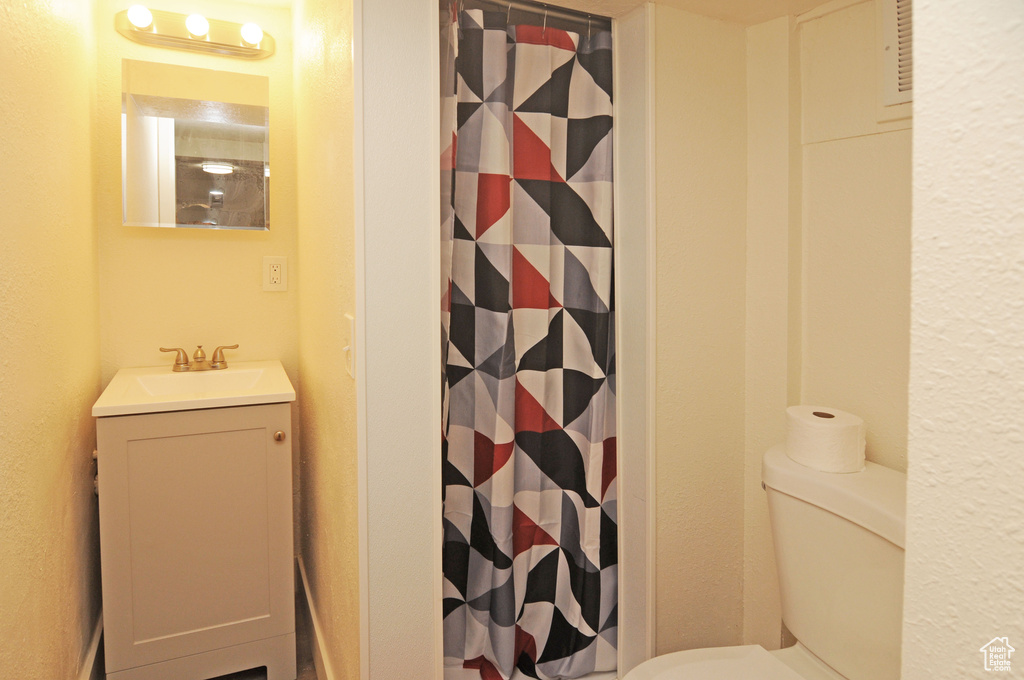 Bathroom with a shower with curtain, vanity, and toilet