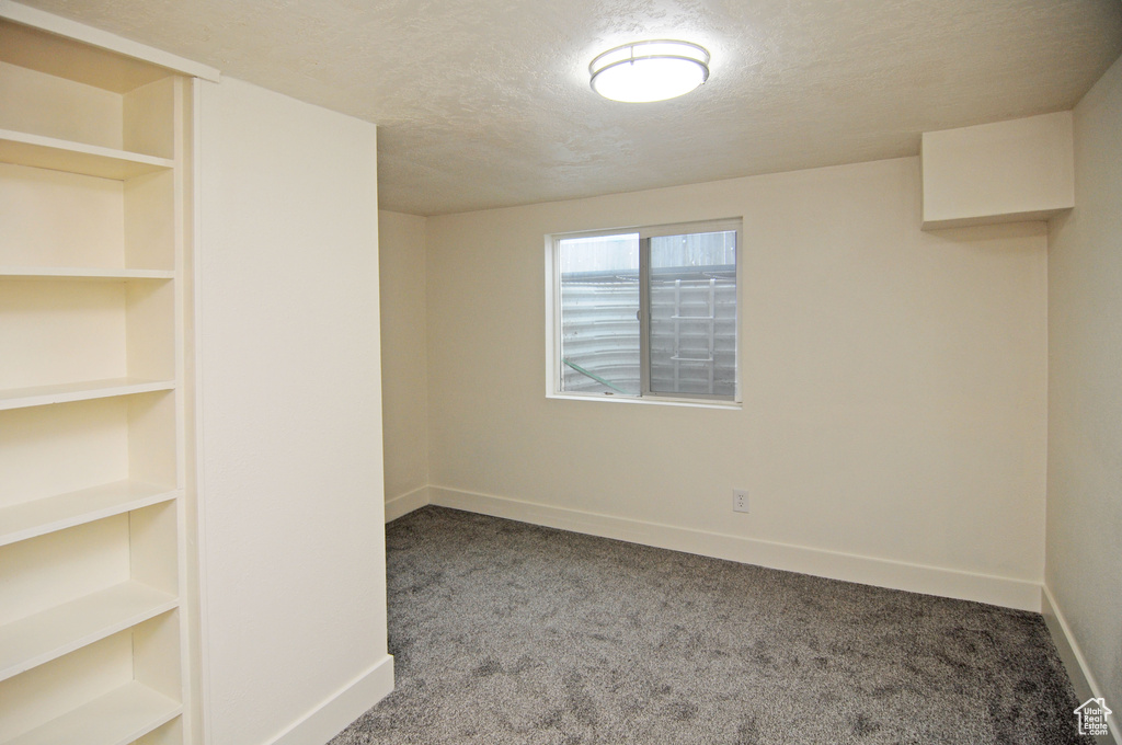 Carpeted empty room featuring a textured ceiling