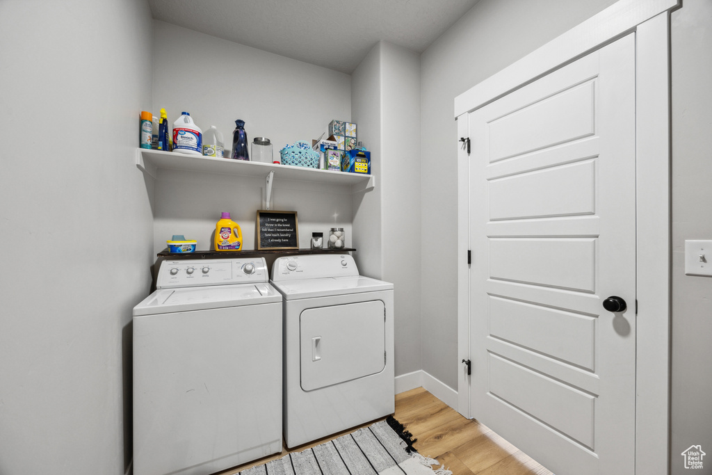 Laundry room featuring light hardwood / wood-style floors and washing machine and clothes dryer