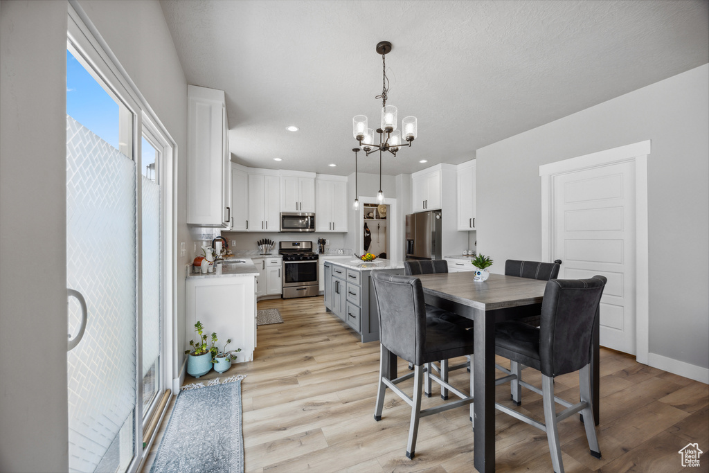 Dining room featuring light wood-type flooring, sink, and a chandelier