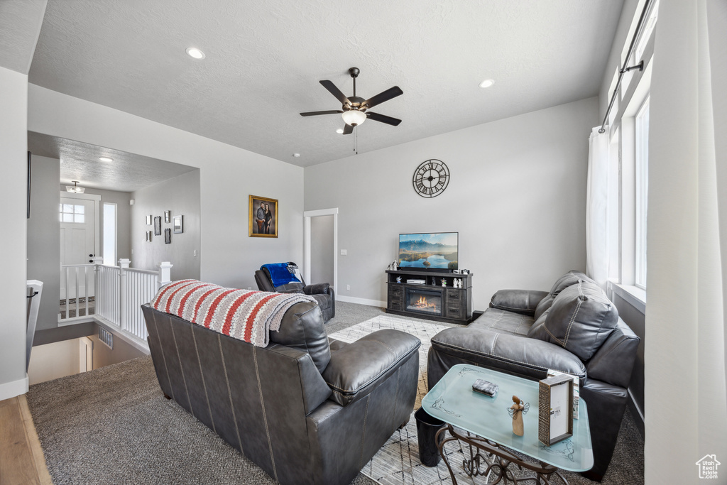 Living room with ceiling fan and light hardwood / wood-style flooring