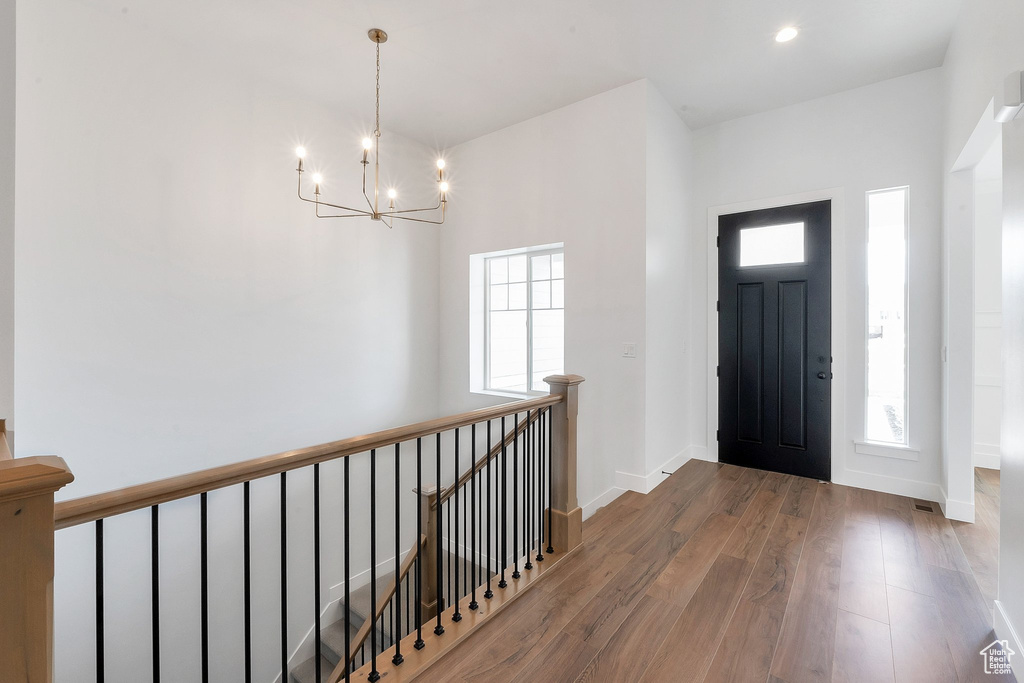 Foyer with hardwood / wood-style flooring and a notable chandelier