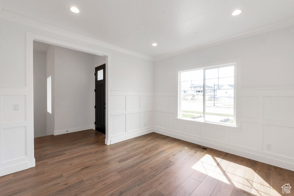 Unfurnished room featuring crown molding and hardwood / wood-style floors