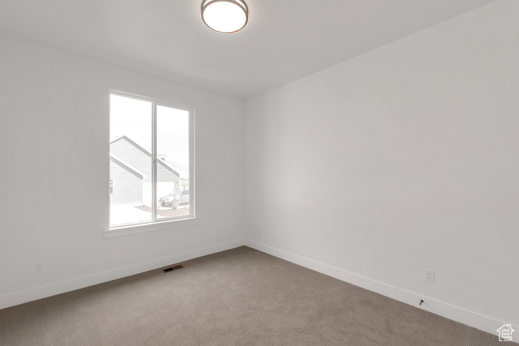 Unfurnished room with plenty of natural light and carpet flooring