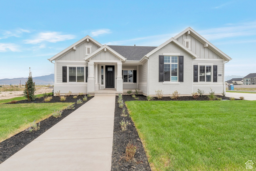 View of front of house featuring a front lawn and a mountain view