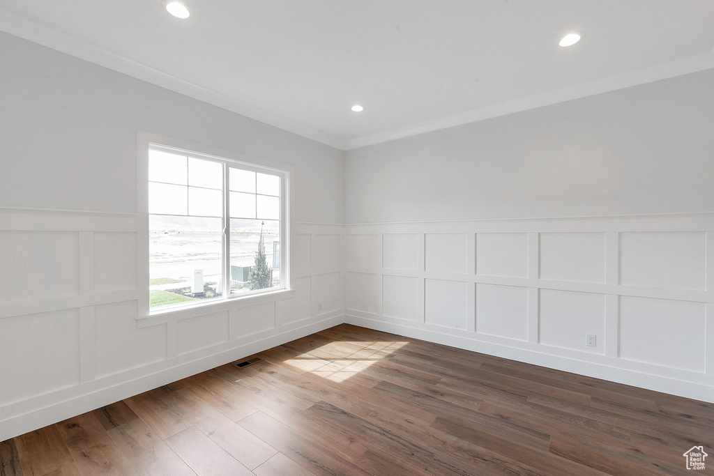 Unfurnished room with crown molding and hardwood / wood-style flooring