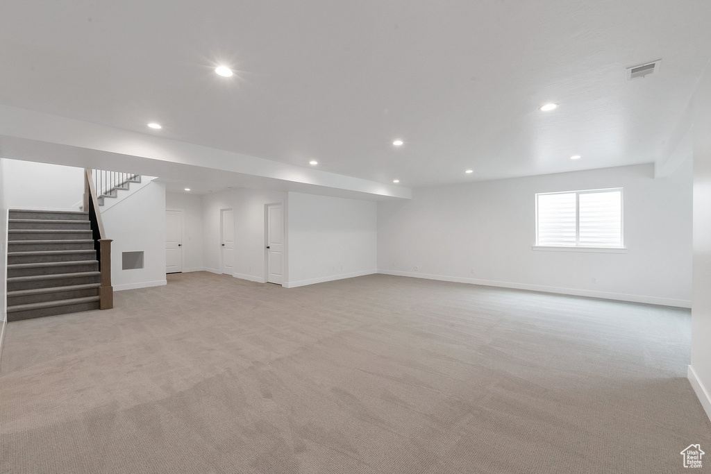 Basement featuring light carpet