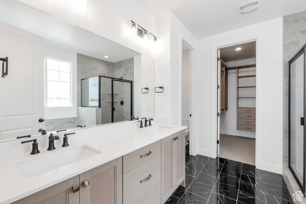 Bathroom featuring vanity and an enclosed shower