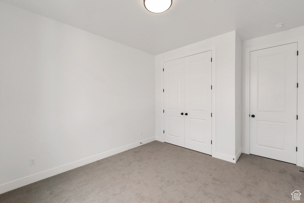 Unfurnished bedroom featuring carpet and a closet