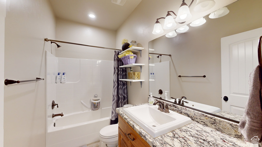 Full bathroom with toilet, vanity, and shower / bathtub combination with curtain