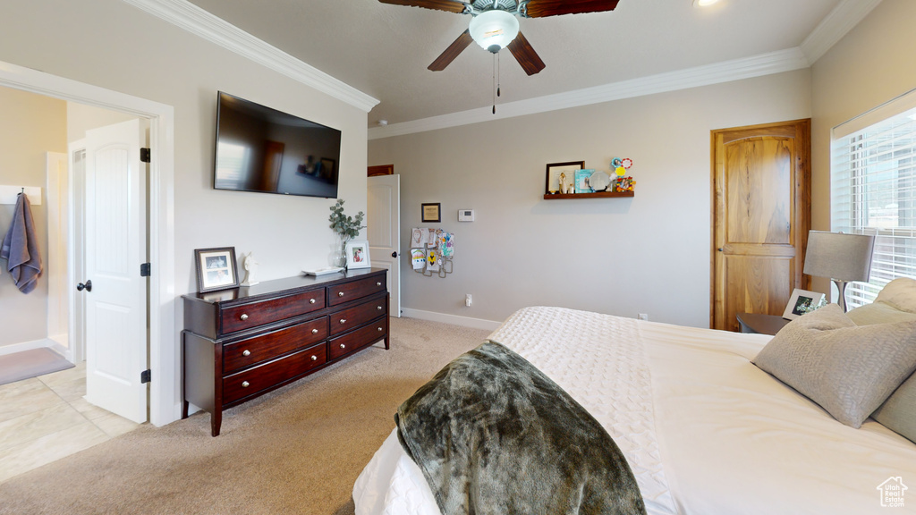 Carpeted bedroom featuring ceiling fan and ornamental molding