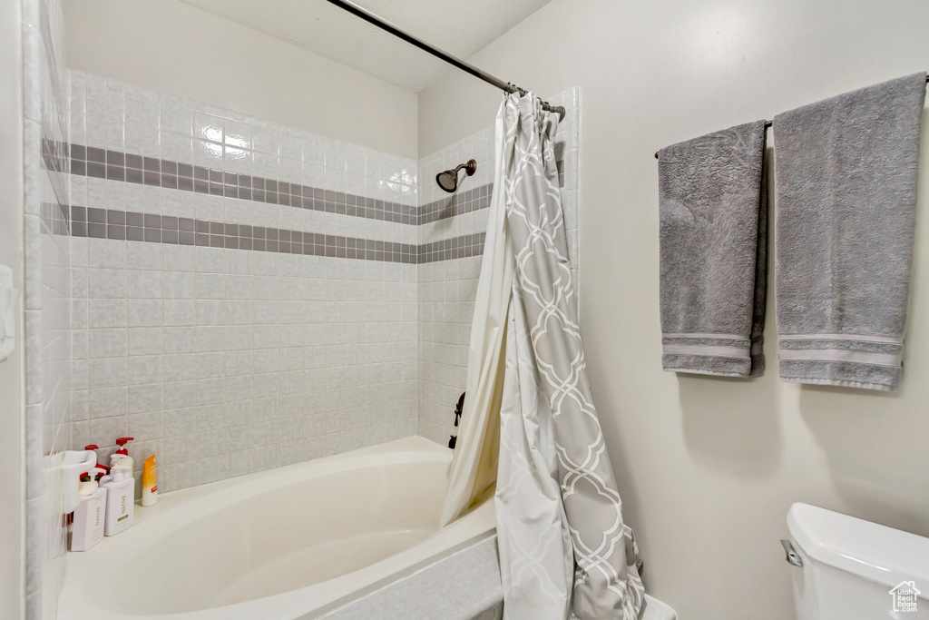 Bathroom featuring toilet and shower / tub combo