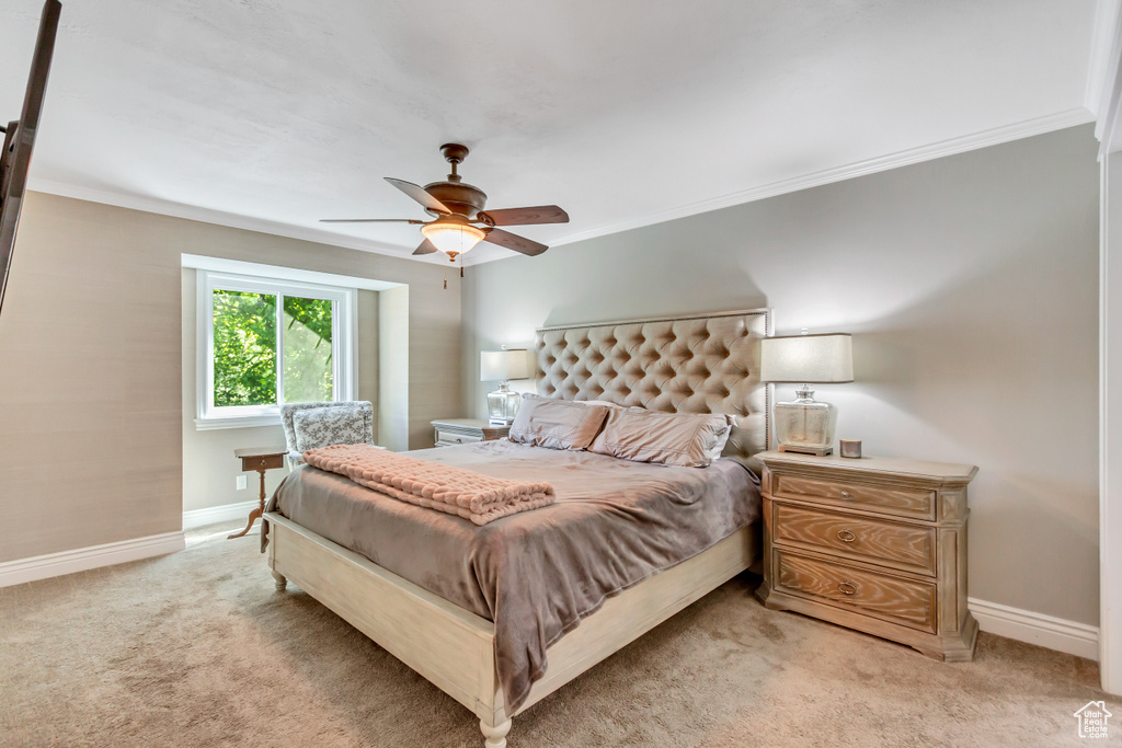 Bedroom featuring ceiling fan, crown molding, and light carpet