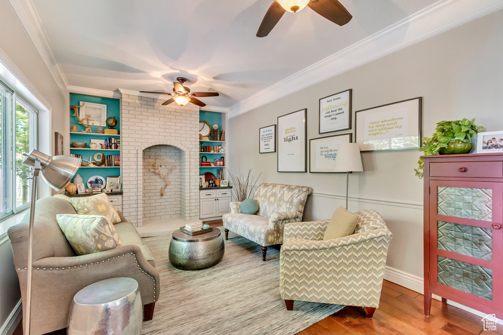 Living room featuring ceiling fan, crown molding, and wood-type flooring