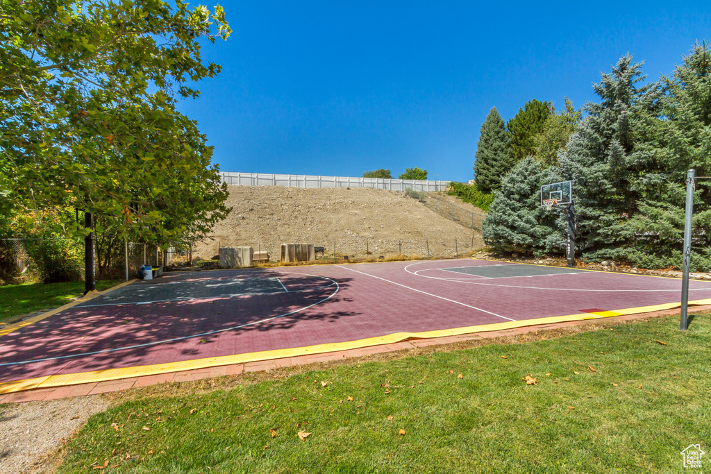 View of sport court with a yard