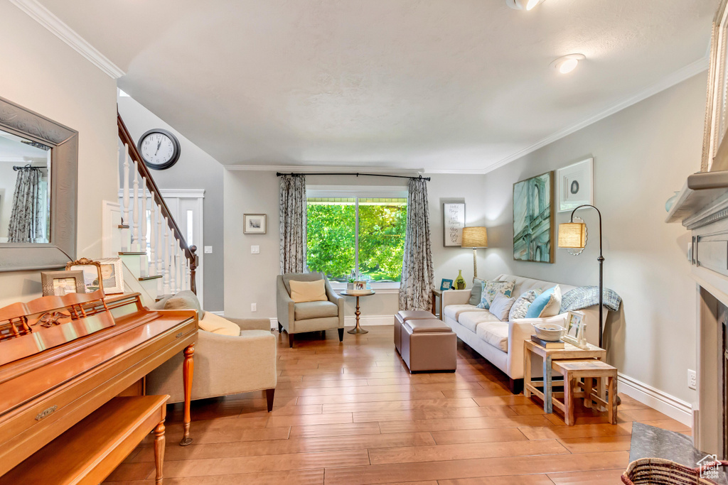 Living room with hardwood / wood-style flooring and ornamental molding