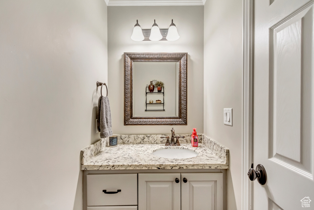 Bathroom with ornamental molding and vanity