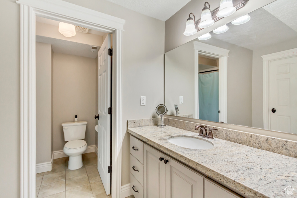 Bathroom with tile patterned flooring, vanity, and toilet