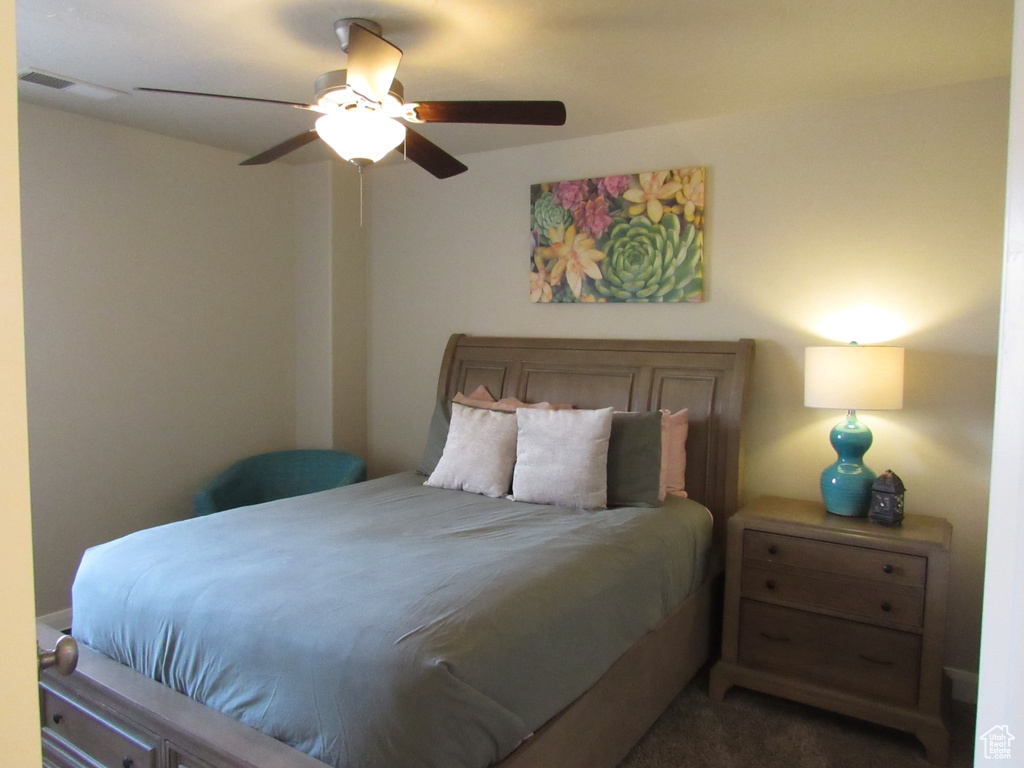 Bedroom featuring ceiling fan and dark colored carpet