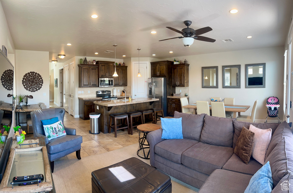 Tiled living room with ceiling fan and sink