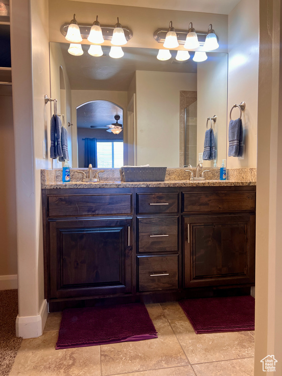 Bathroom with ceiling fan, tile patterned floors, vanity, and a shower with shower door