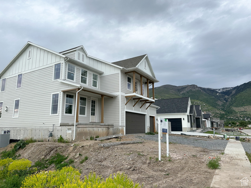 View of home's exterior with board and batten siding, a mountain view, and a garage