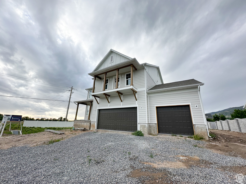 View of front of house with driveway, fence, a garage, and board and batten siding