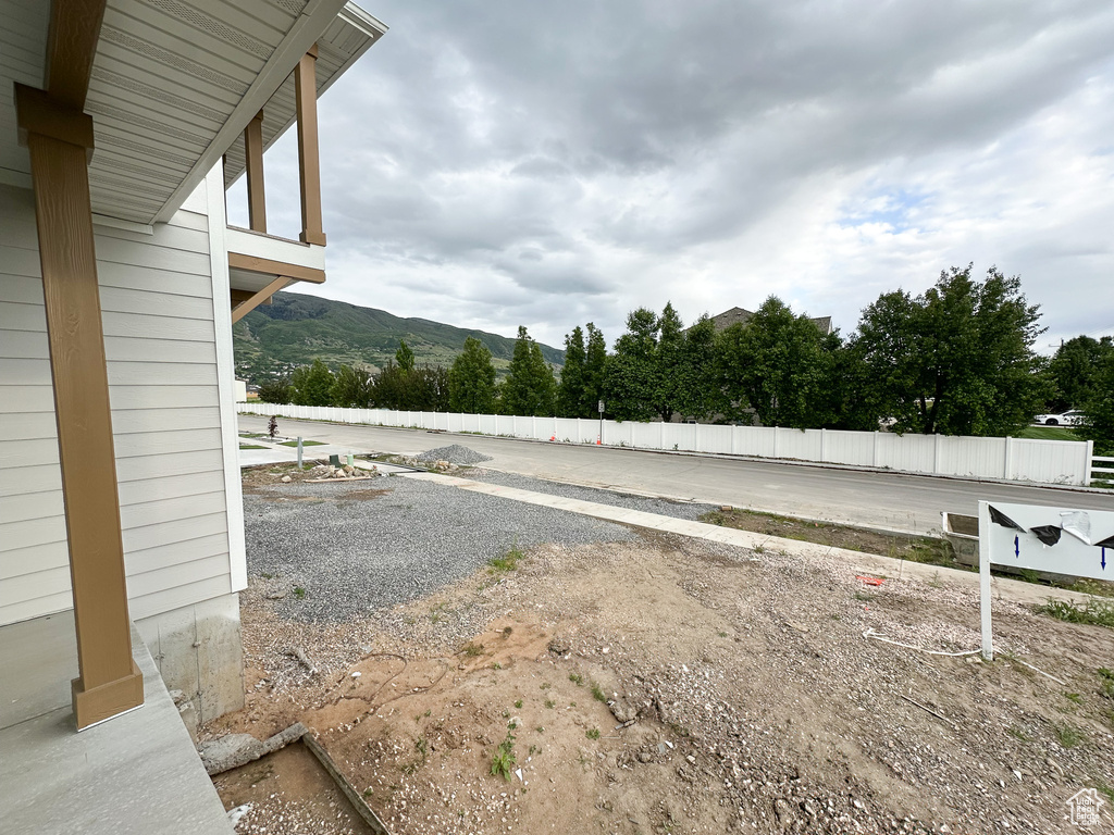 View of yard with a mountain view and fence