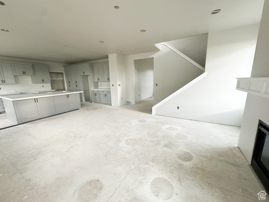 Unfurnished living room featuring a fireplace and stairway