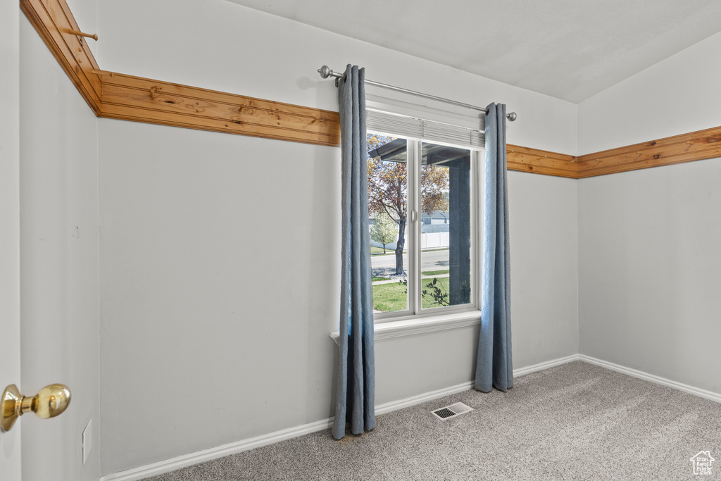 Carpeted empty room with visible vents and baseboards