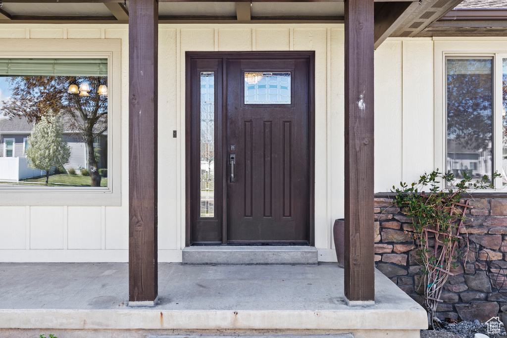 Entrance to property with board and batten siding and covered porch