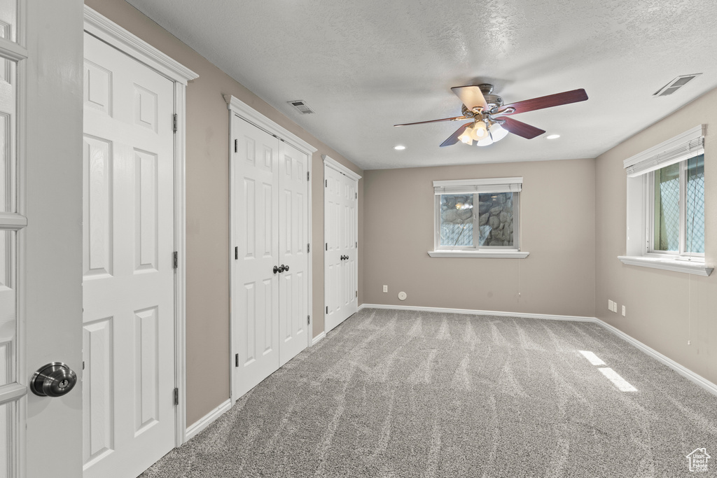 Unfurnished bedroom with visible vents, multiple closets, baseboards, and multiple windows