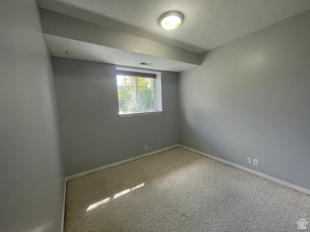 Carpeted spare room featuring a textured ceiling
