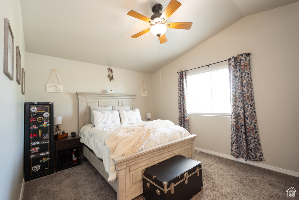 Carpeted bedroom with ceiling fan and lofted ceiling