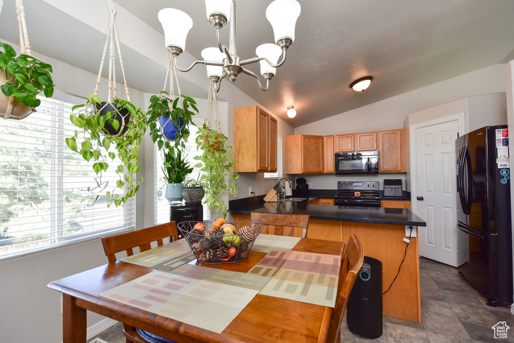 Dining area with vaulted ceiling, an inviting chandelier, sink, and tile patterned flooring