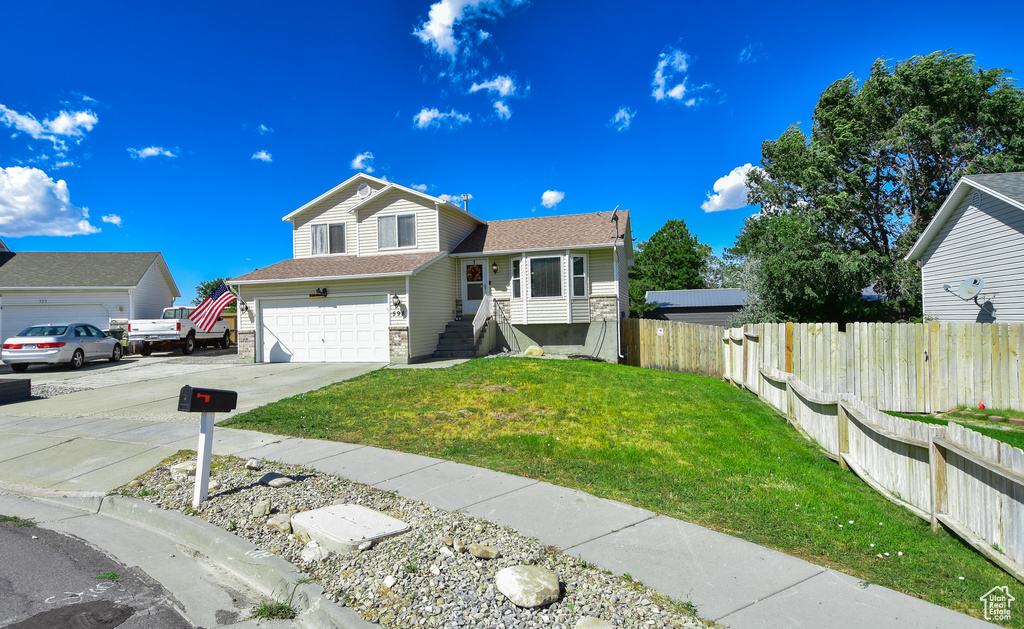 View of front of property featuring a garage and a front yard