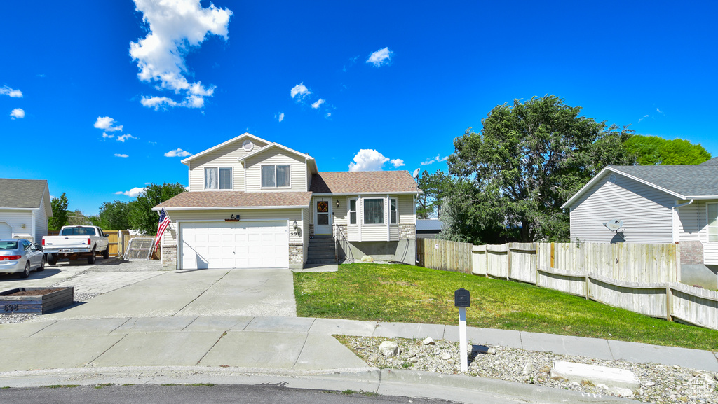 View of front facade with a garage and a front lawn