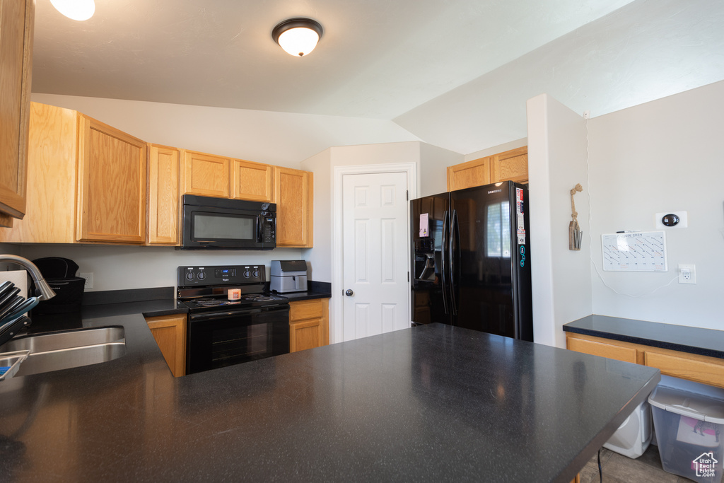 Kitchen featuring lofted ceiling, sink, and black appliances