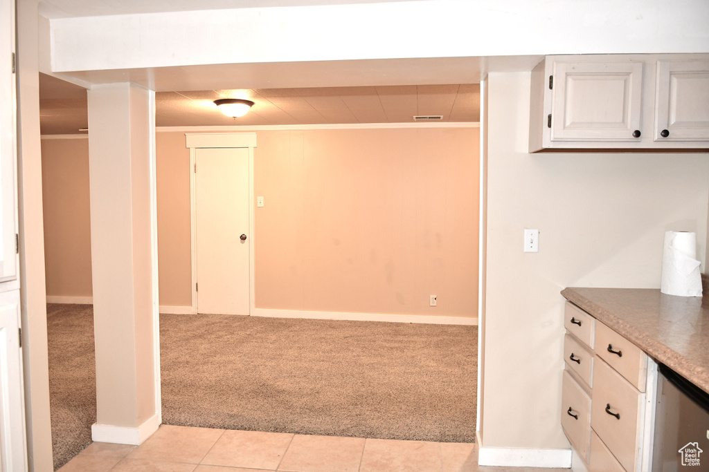 Kitchen with white cabinetry and light tile patterned floors