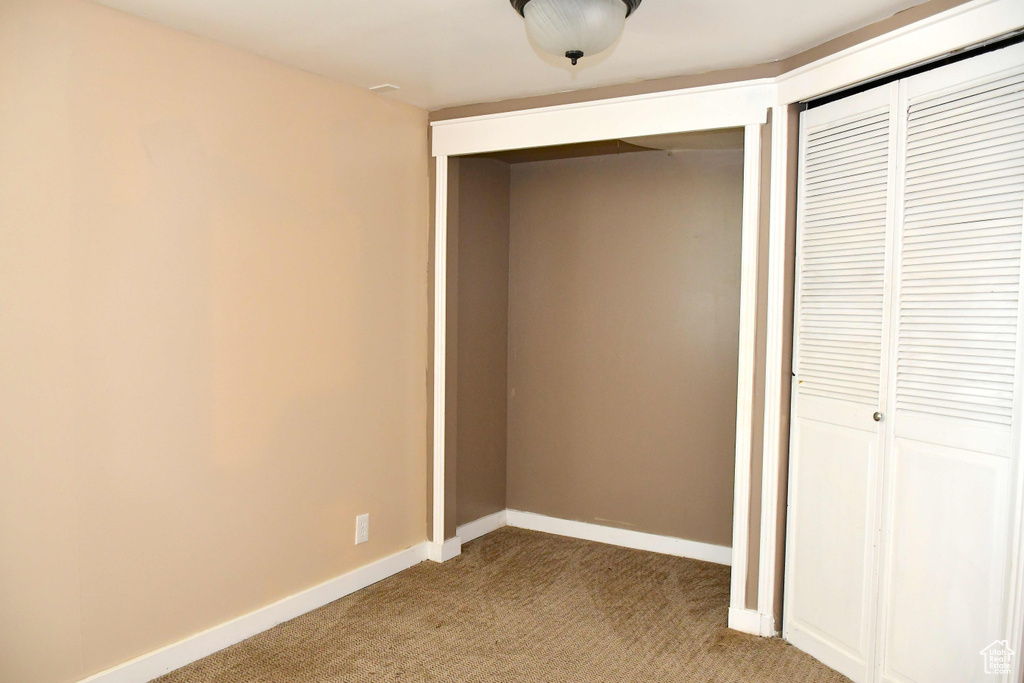 Unfurnished bedroom featuring light colored carpet and a closet