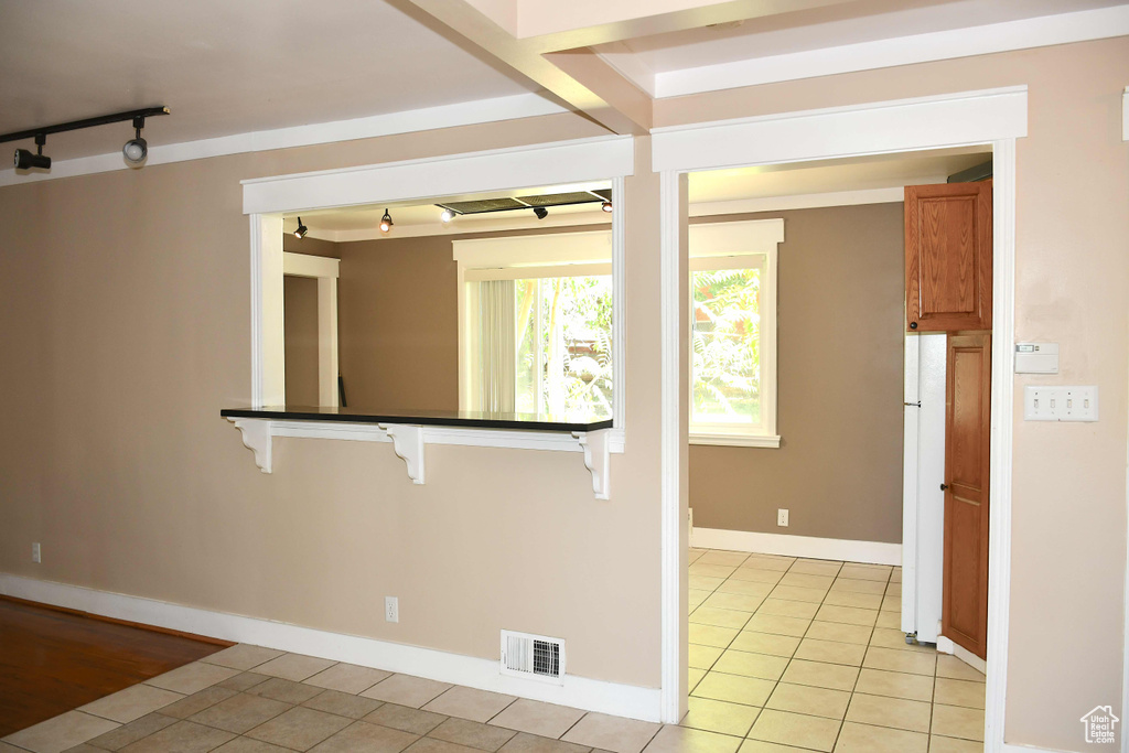 Kitchen with light tile patterned floors and track lighting