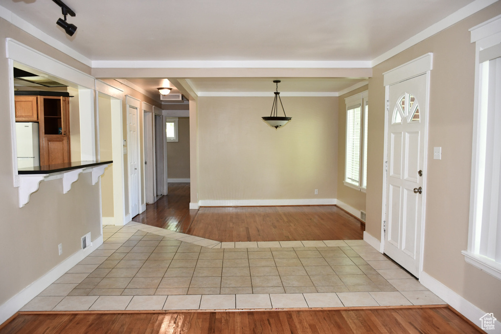 Tiled entryway featuring track lighting